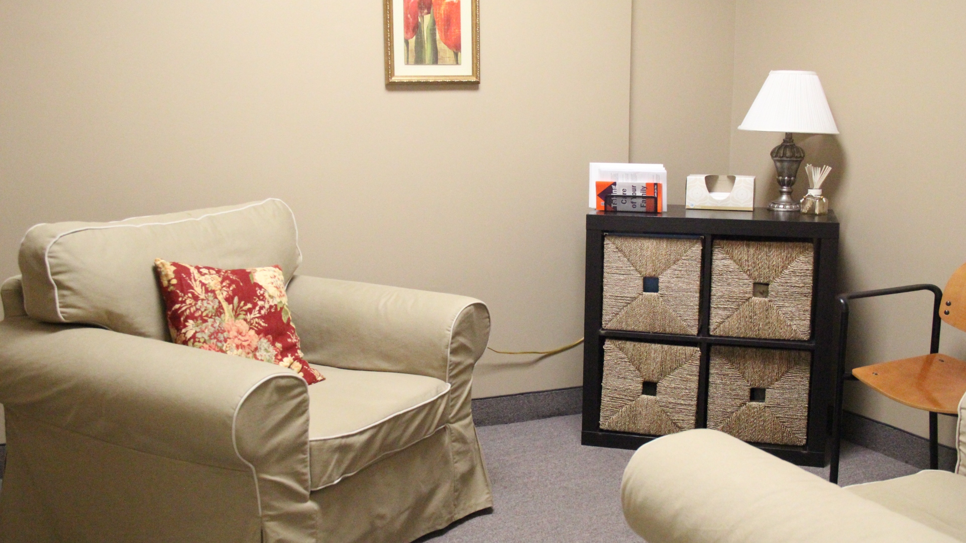 A quiet corner with a chair, lamp, and stack of patient information booklets.
