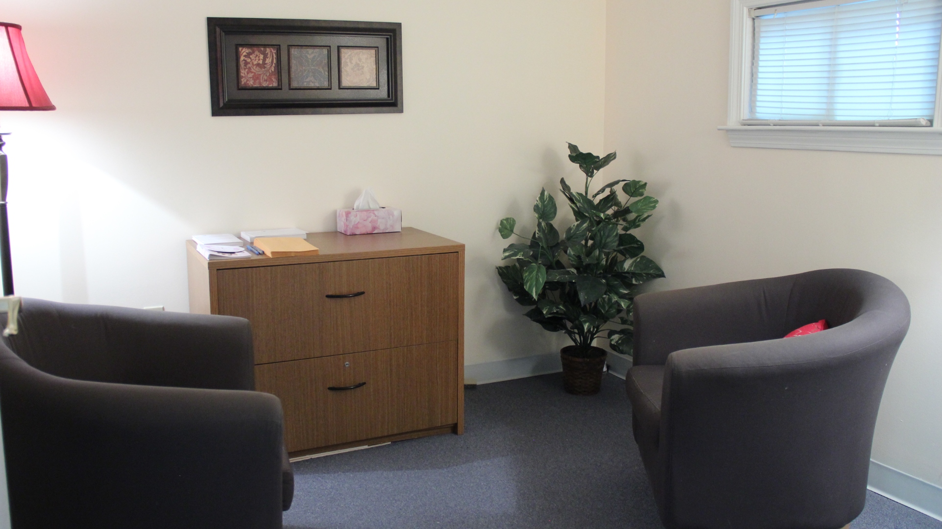 A bright window in a clinic room with a single chair beside it.